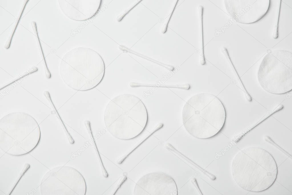 Top view of cotton cticks and cosmetic pads on white background