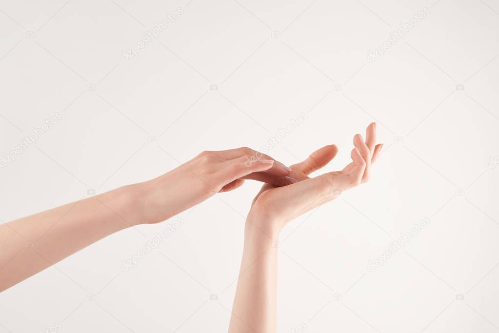 Partial view of well-cared female hands on white background