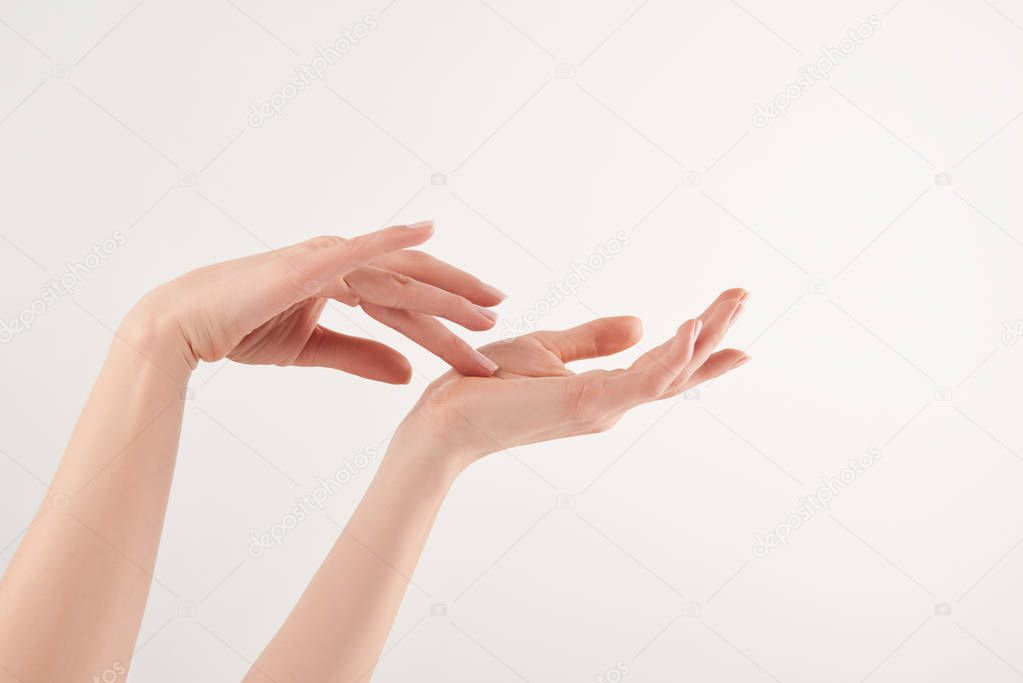 Partial view of female well-cared hands on white background