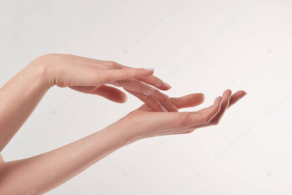 Partial view of female well-cared hands on white background
