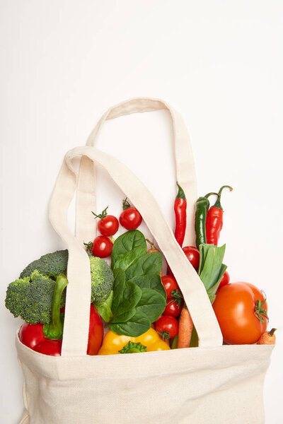 Studio shot of eco bag with vegetables on white background