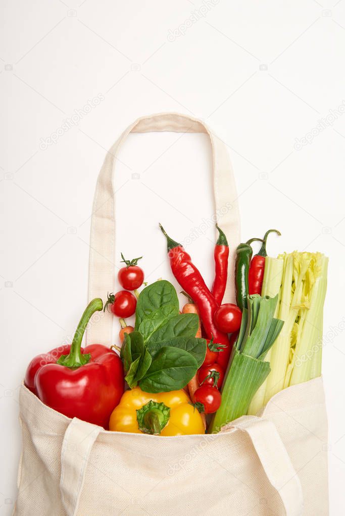 Studio shot of eco bag with natural vegetables on white background