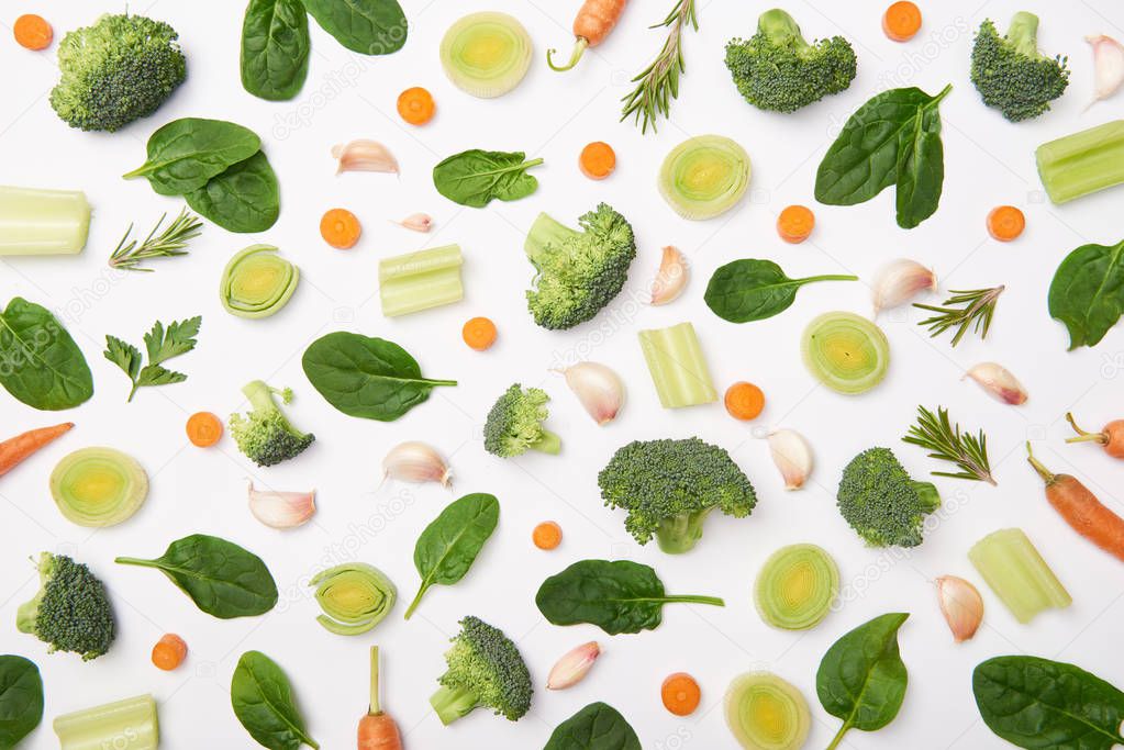 Flat lay with cut vegetables, rosemary and spinach leaves on white background