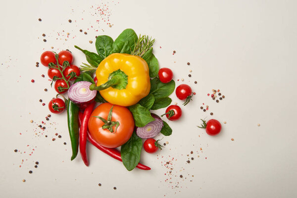 Top view of fresh vegetables and spices on grey background