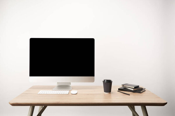 workplace with coffee to go, notebooks and desktop computer with copy space isolated on white