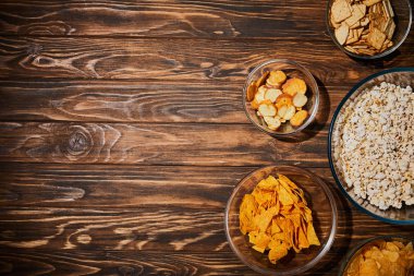 top view of snacks in bows on wooden table clipart