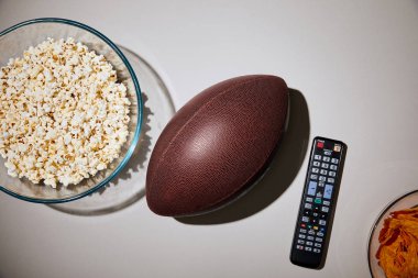 futbol ve uzaktan kumanda beyaz arka plan üzerinde yakın üstten görünüm lezzetli aperatifler cam kase