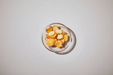 top view of salty snack in glass bowl on white background clipart