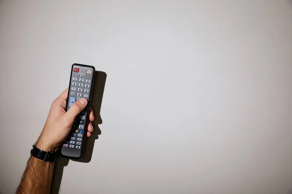 Vista Recortada Del Hombre Sosteniendo Control Remoto Mano Sobre Fondo —  Fotos de Stock