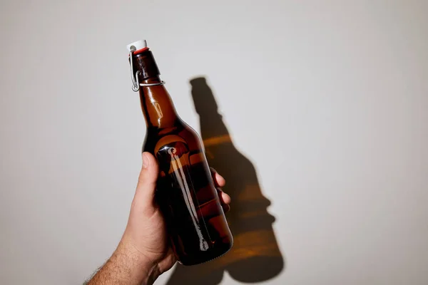 Vista Recortada Del Hombre Sosteniendo Botella Con Cerveza Sobre Fondo —  Fotos de Stock