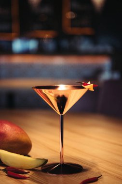 biber biber, nacho çip ve mango ahşap masa üzerinde metal cam alkollü kokteyl süslenmiş