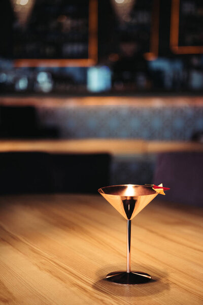 Алкогольный коктейль в металлическом стекле, украшенный перцем чили и чипсами начо на темном фоне с копировальным пространством
