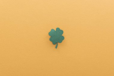 top view of shamrock isolated on orange with copy space, st patrick day concept clipart