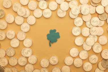 top view of golden coins with dollar signs and shamrock isolated on orange, st patrick day concept clipart