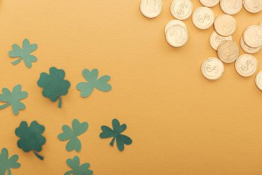 top view of golden coins with dollar signs, shamrocks and copy space isolated on orange, st patrick day concept clipart