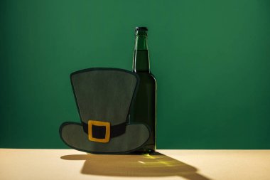 bira şişeleri ve kağıt şapka izole yeşil, st patrick günü kavramı