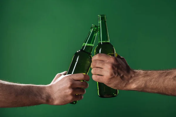 裁剪视图的男子叮当作响的啤酒瓶隔离在绿色 帕特里克天的概念 — 图库照片