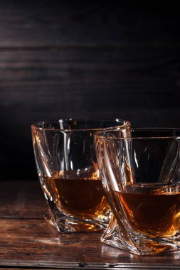 iki kadeh viski koyu ahşap masa üzerinde görmek
