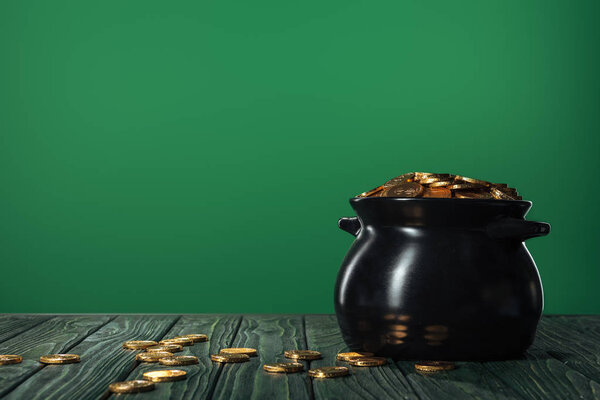 golden coins in pot isolated on green with copy space, st patrick day concept