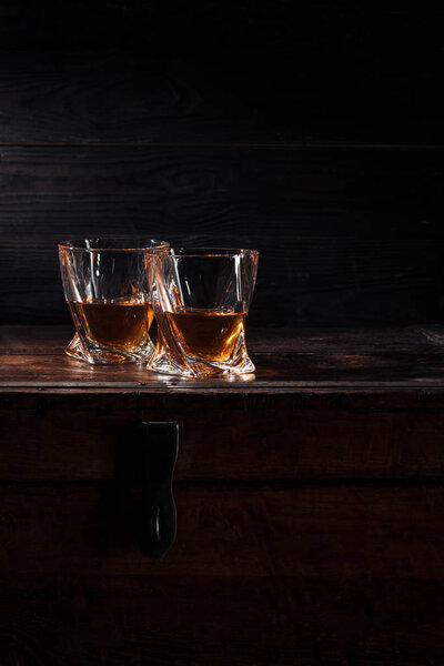 two glasses of whiskey on vintage wooden table  