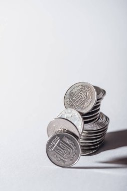 ruined stack of silver ukrainian coins on grey background clipart