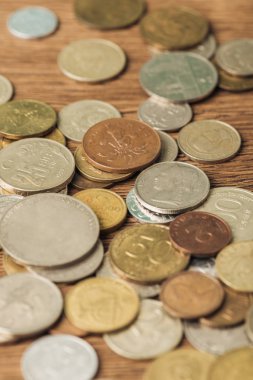 selective focus of silver and golden coins laid out on wooden background clipart