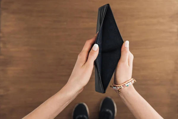 Vista Superior Mujer Sosteniendo Cartera Vacía Sobre Fondo Madera — Foto de Stock