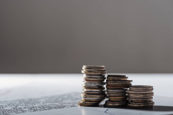 selective focus of coins stacks on document and blurred grey background