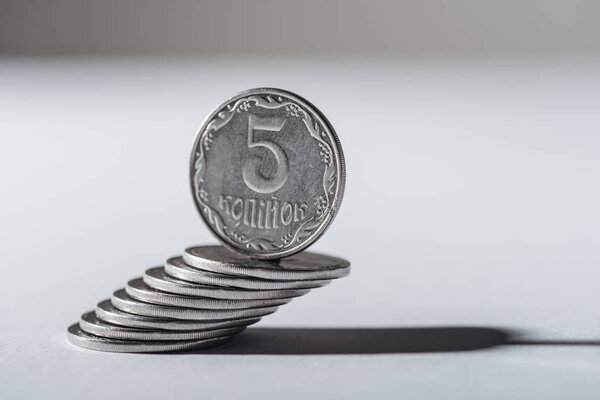 ukrainian coin on coins stack with grey blurred background