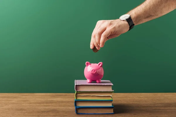 Mann Steckt Rosa Sparschwein Münze Auf Bücher Holztisch Und Grünen — Stockfoto