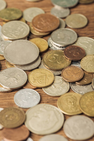 selective focus of different silver and golden coins on wooden background