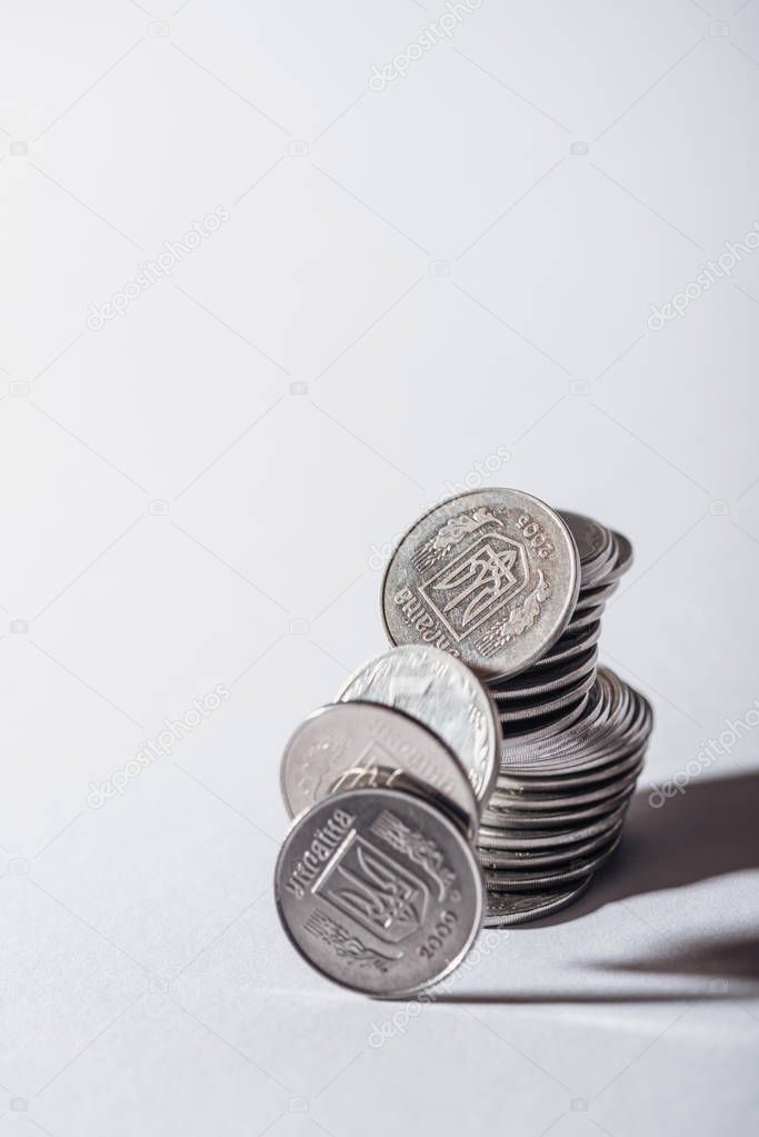 ruined stack of silver ukrainian coins on grey background