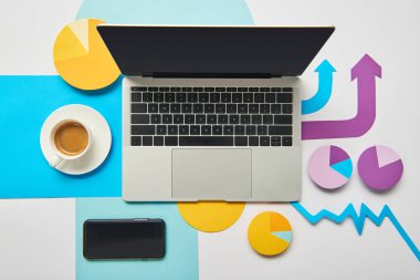 fincan kahve, kağıt çizelgeleri ve grafik, beyaz arka plan üzerinde işaretçiler ile dizüstü üstten görünüm