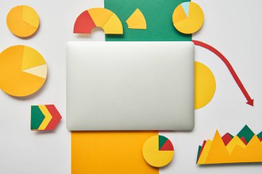Beyaz arka plan üzerinde kağıt tablolar ve grafikler, işaretçiler, sayfanın kağıt ve dizüstü üstten görünüm