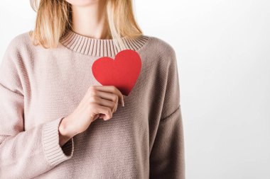Cropped view of woman in beige sweater holding paper heart clipart