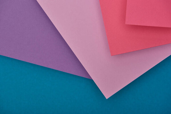 top view of purple, blue and fuchsia paper sheets with copy space