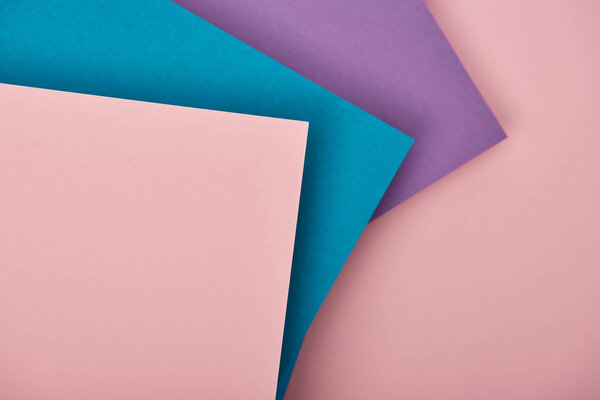 top view of violet, blue and pink paper sheets with copy space
