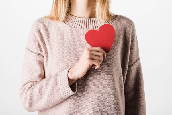 Partial view of blonde woman in beige sweater holding paper heart