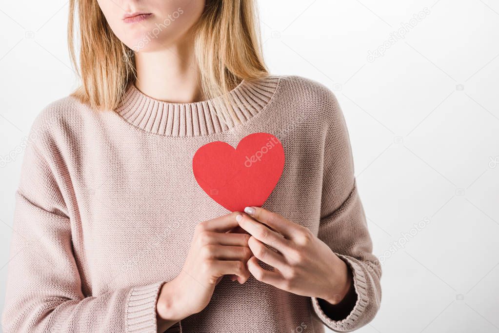Partial view of woman in beige sweater holding paper heart