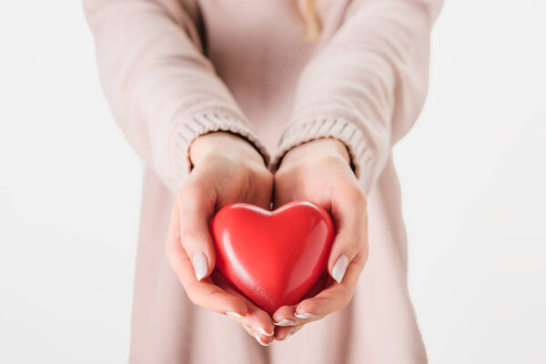 Cropped view of woman holding toy heart on grey background