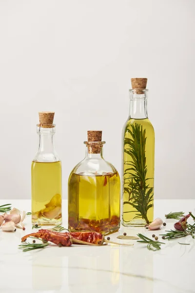 Various Bottles Oil Flavored Rosemary Different Spices White Surface — Stock Photo, Image