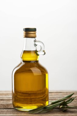 izole üzerinde gri bir şişe petrol ve zeytin ağacı yaprakları 