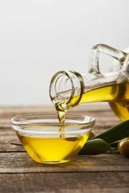 cam kase, zeytin ağacı yaprakları ve zeytin ahşap yüzeyde içine yağ boşaltma