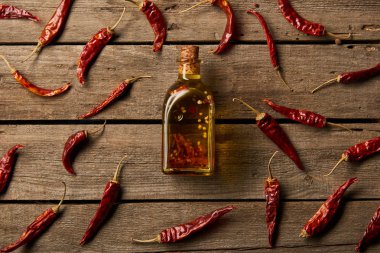 şişe aromalı yağ ve red hot chili peppers ile üstten görünüm ahşap arka plan üzerinde