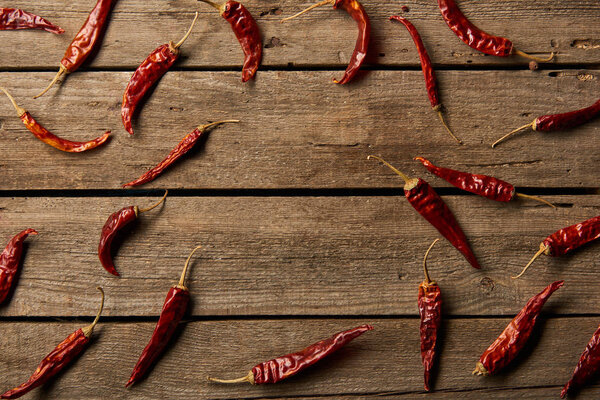 top view of red hot chili peppers on wooden background