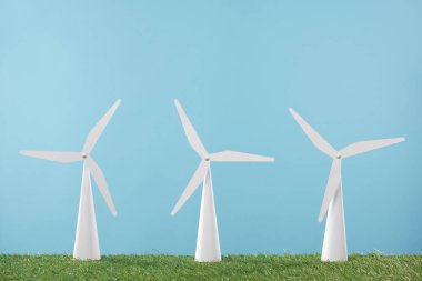 white windmill models on grass and blue background    clipart
