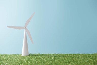windmill model on green grass and blue background with copy space clipart