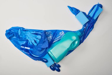 Lastik eldiven, plastik tabak, bardak, süngerler, kaşık, çanta ve şişe üzerinde beyaz izole yapılmış balina figür üstten görünüm