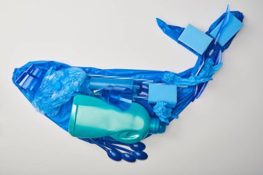 Kauçuk eldivenler, tek kullanımlık plastik sofra, çanta, sünger ve şişe üzerinde beyaz izole yapılmış balina figür üstten görünüm