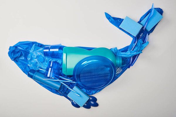 top view of whale made from disposable plastic tableware, bag, bottle, sponges and rubber gloves isolated on white